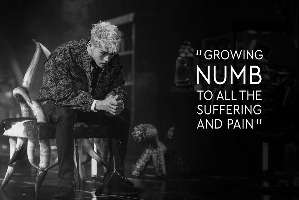 Black and white photo of BM of KARD sitting during his "Broken Me" Music video produced by 8Pex and Vive studios with quote "GROWING NUMB TO ALL THE SUFFERING AND PAIN"