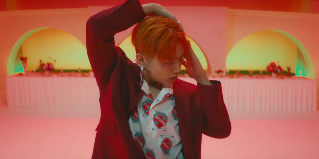 Singer Sam Kim dancing in vibrant suit in his music video for his song, "The Juice."