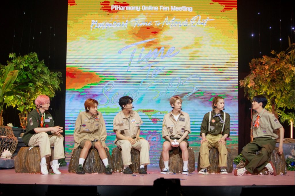 Group photo of P1HARMONY sitting on tree stumps and in a wilderness setting for theri https://www.weverse.io/p1harmony/notices/1289
