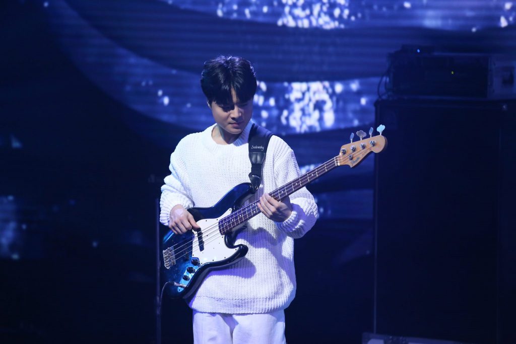 Korean indie band OurR's bassist Park Jinkyu performing at a concert.